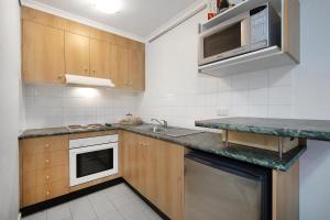 a kitchen with a sink and a microwave at Moonya Courtyard in Carnegie