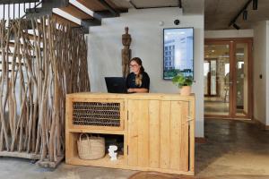 a woman sitting at a desk with a laptop at Babel Community Hôtel - Montpellier centre in Montpellier