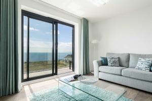 a living room with a couch and a large window at Beachcliff - On the Seafront with Two Balconies in Bournemouth