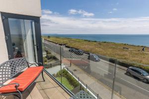 a balcony with a chair and a view of the ocean at Beachcliff - On the Seafront with Two Balconies in Bournemouth