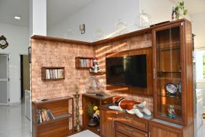 a living room with a tv and a brick wall at Hureshan Villa in Negombo +64 photos