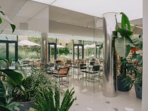 a restaurant with tables and chairs and plants at Hotel Josef in Prague