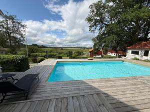 a swimming pool on a wooden deck next to a house at Safety System Show Jumps in Enköping