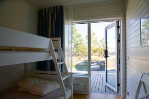a bedroom with a bunk bed and a door to a porch at KSSS Vandrarhem Telegrafholmen in Sandhamn