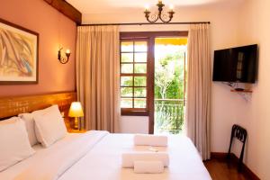 a bedroom with a white bed with a window at Pousada Chão de Minas in Cachoeira do Campo +93 photos