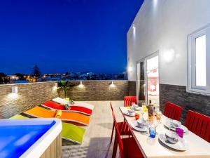 a balcony with a table and chairs and a pool at Bayside Apartments in St. Julianʼs