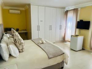 a bedroom with a bed with a teddy bear on it at Umsobomvu Guest House in Mthatha