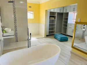 a large bathroom with a tub and a shower at Umsobomvu Guest House in Mthatha +21 photos