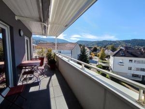 a balcony with chairs and a view of a city at L'Escampette, superbe appartement avec terrasse in Gérardmer