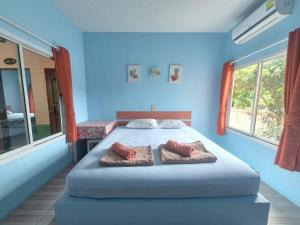 a blue bedroom with a bed with two pillows on it at Sam roi yot Sea sight Resort in Sam Roi Yot