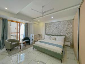 a bedroom with a king sized bed and a chair at Aqua Epic Residence in Mombasa +14 photos