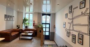 a living room with a couch and a table at Logis Hôtel de Paris - Restaurant - Pâtisserie in Saint-Avold