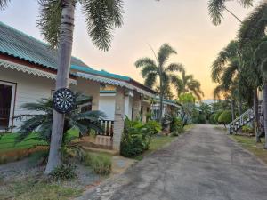 a house with a palm tree next to a street at Sam roi yot Sea sight Resort in Sam Roi Yot