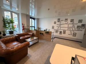 a living room with couches and a drawing on the wall at Logis Hôtel de Paris - Restaurant - Pâtisserie in Saint-Avold