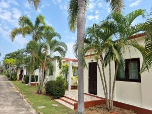 a house with palm trees in front of it at Sam roi yot Sea sight Resort in Sam Roi Yot