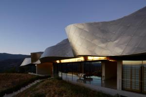 a building with a large roof on top of a hill at Vik Chile in San Vicente de Taguatagua