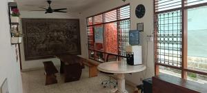 a living room with a table and a ceiling fan at Dhika Adventure DPS in Denpasar