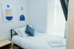 a bedroom with a bed with a blue pillow and a window at Glen Allan Hotel in Blackpool +25 photos