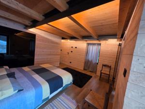 a bedroom with a bed and a wooden ceiling at Muranche Loft S1 in Valtournenche