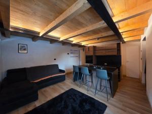 a living room with a couch and a bar with stools at Muranche Loft S1 in Valtournenche