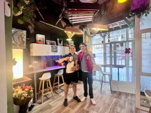 two people are standing in a room with a bar at HOSTEL Pepper-Gold -STEP-FREE ENTRANCE -car- free Space-no nois-3 minutes from Port -BED ROOMS 8 GUEST 55 M2 AND 8 GUEST 65 M2 in Alicante