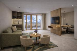 een woonkamer met een bank en een tv bij Kitzhorn Suites in Sankt Johann in Tirol