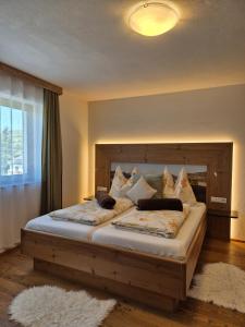 a bedroom with a large bed with a wooden headboard at Seyerlehnerhof in Maria Neustift