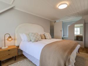 a bedroom with a large white bed and a mirror at Salt & Butter in Hermanus +27 photos