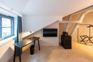 ein Zimmer mit Schreibtisch und Fernseher im Dachgeschoss in der Unterkunft qnorke Hotel in Berlin