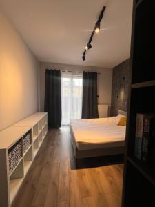 a bedroom with two beds and a window at Apartament Augustynika in Dąbrowa Górnicza