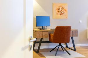 a desk with a computer monitor and a chair at Altstadt Loft XL I 90 qm I 2 Schlafzimmer I 2 Arbeitsplätze I 6 Gäste in Passau