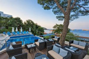 a resort with a pool and chairs and a tree at Royal Neptun Hotel in Dubrovnik
