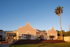 a house with a palm tree in front of it at Issaquena Heights Boutique Hotel in Knysna