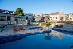 a house with a swimming pool next to a house at Issaquena Heights Boutique Hotel in Knysna