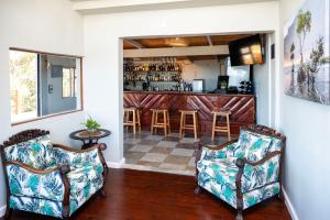 a living room with two chairs and a bar at Issaquena Heights Boutique Hotel in Knysna
