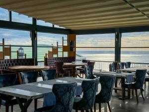 a restaurant with tables and chairs and a view of the water at Qoople Elite Admiral Apartment in Alanya