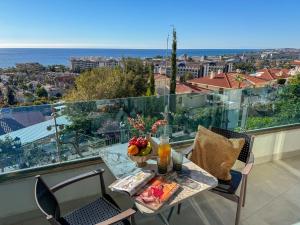 a table with a bowl of fruit on a balcony at Qoople Elite Admiral Apartment in Alanya