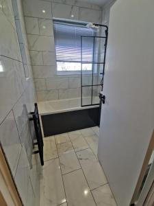 a bathroom with a shower with a window and a door at Victoria Guest Apartment in Ramsgate