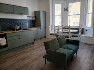 a kitchen and dining room with a couch and a table at Victoria Guest Apartment in Ramsgate