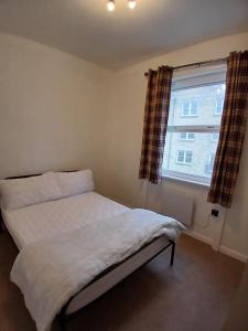 a small bedroom with a bed and a window at Victoria Guest Apartment in Ramsgate