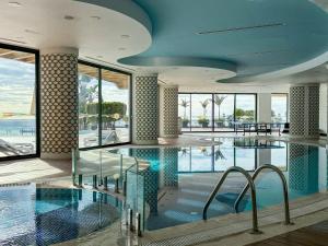 a swimming pool in a hotel with glass floors and windows at Qoople Elite Admiral Apartment in Alanya