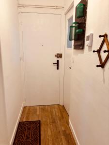 a hallway with a white door and a wooden floor at Le beffroi in Abbeville +2 photos
