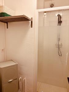 a shower with a glass door in a bathroom at Le beffroi in Abbeville