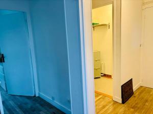 an empty room with a blue door and a hallway at Le beffroi in Abbeville