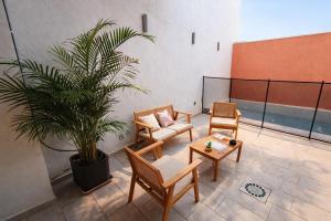 a room with two chairs and a potted plant at Apartamento Maya Merida in Mérida