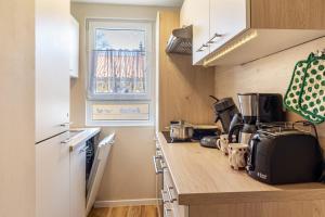 a kitchen with a counter top with a window at Ferienhaus Biber im Sternenpark in Lochow +7 photos