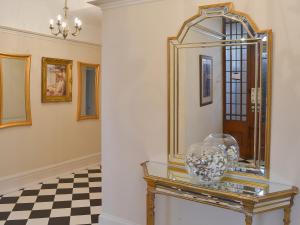 a mirror on a table in a room with a checkered floor at Sandfield The Promenade in Southport