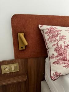a bed with a pillow and aswitch on a wall at Adonis Collection La Baule in La Baule
