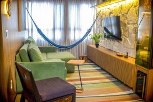 a living room with a couch and a tv at Apê catedral centro in Goiânia