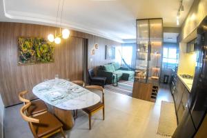 a room with a table and chairs and a living room at Apê catedral centro in Goiânia